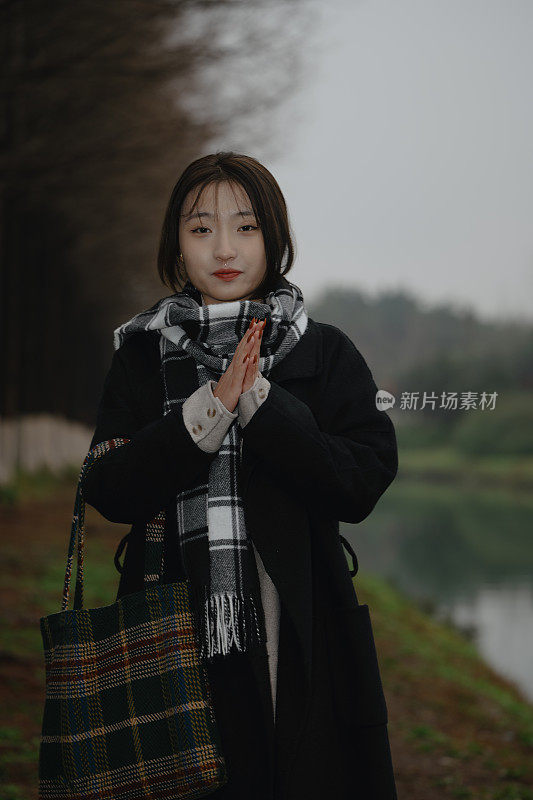 Asian girl walking by the river in rainy weather